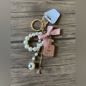 NWT: A parfum bottle with pink ribbon purse charm or keychain.